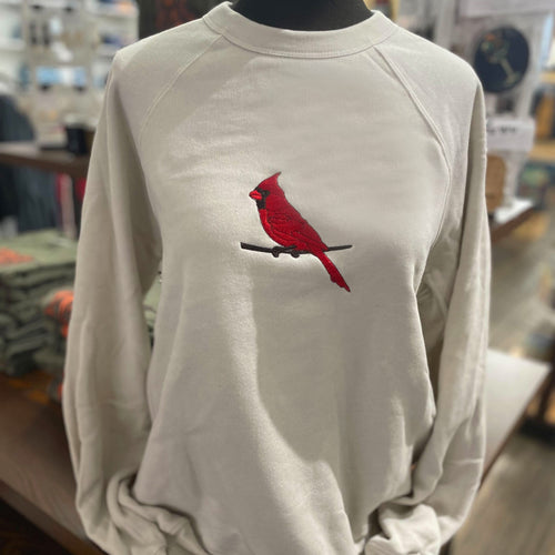 White sweatshirt with a red cardinal bird design on a mannequin in a store setting.